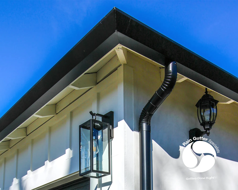 Black aluminum rain gutters with decorative rain chain in Altadena